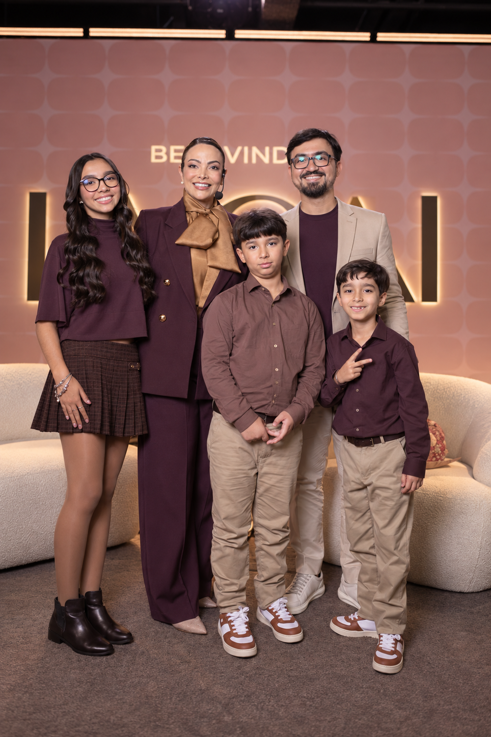 Dra. Fabiana Caetano e o Dr. Lins Caetano com os três filhos, Laura Lins, Gael e Ian, diante do painel da Lagai