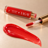 Gloss Labial Red Moon da Lagai com a textura vermelha brilhante espalhada ao lado do tubo e do aplicador, em fundo bege.