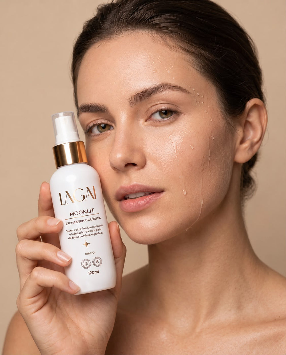 Mulher segurando o frasco da Bruma Dermatológica MoonLit 120 ml da Lagai junto ao rosto, com a pele hidratada e luminosa depois da borrifada.